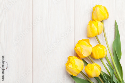 Fototapeta Naklejka Na Ścianę i Meble -  Yellow tulips over wooden table