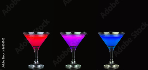 Cosmopolitan cocktail in nice red, purple and blue in front of a black background