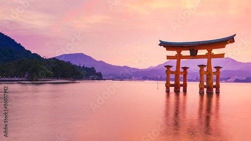 Sunset time-lapse of the famous orange shinto gate (Torii) of Miyajima island of Hiroshima prefecture, Japan. photo