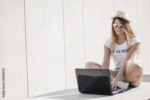 Stylish Young Woman Using her Laptop on the Bench photo