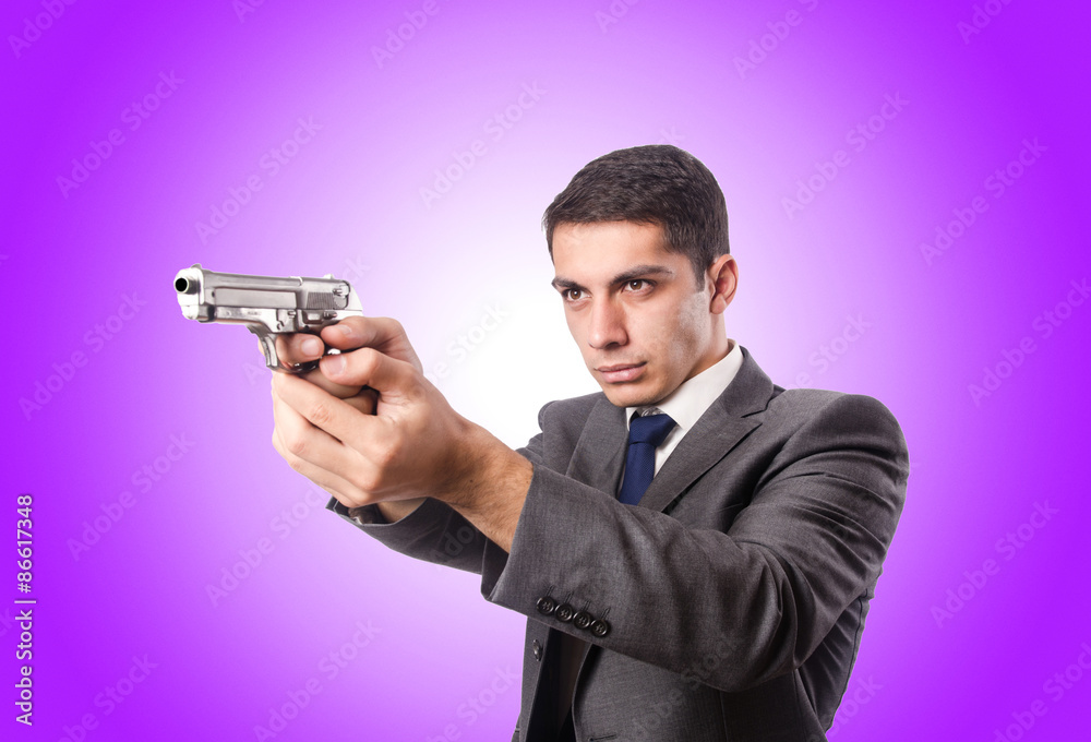 Businessman with gun against the gradient Businessman with gun against the gradient