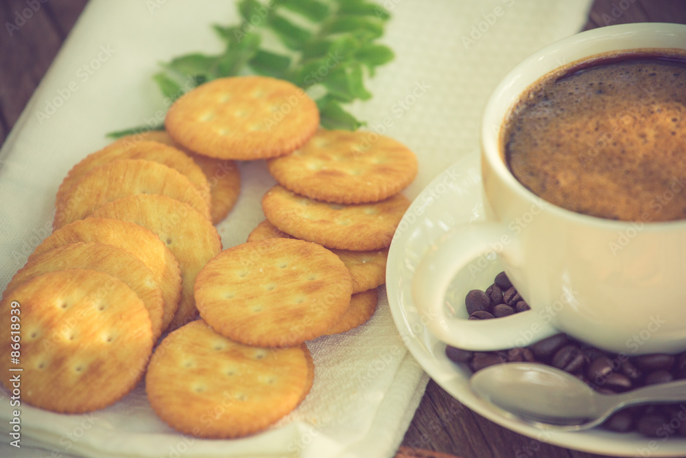 Cup of coffee on a wooden board and biscuits vintage color Cup of coffee on a wooden board and biscuits vintage color