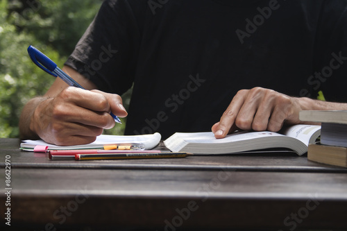 young man studing and taking notes photo