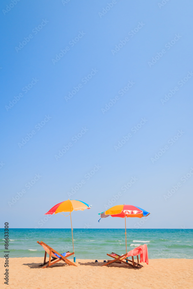 Blurred image of beach chair and umbrella on sand beach