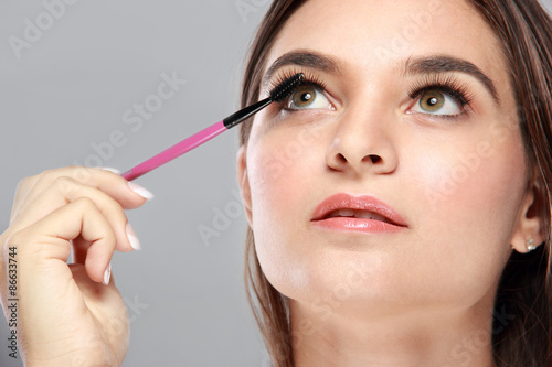beautiful caucasian model applying mascara