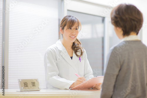 カウンター越しに患者の話を聞く女性薬剤師 Stock 写真 Adobe Stock
