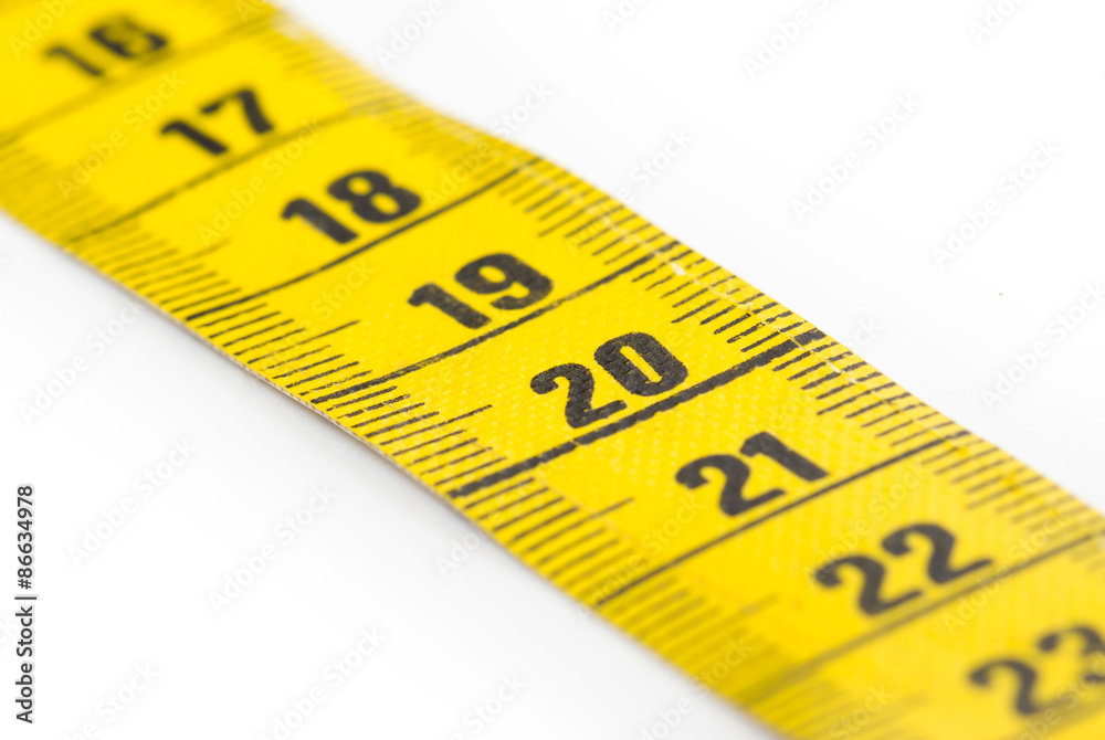 Yellow measuring tape isolated - selective focus Yellow measuring tape isolated - selective focus