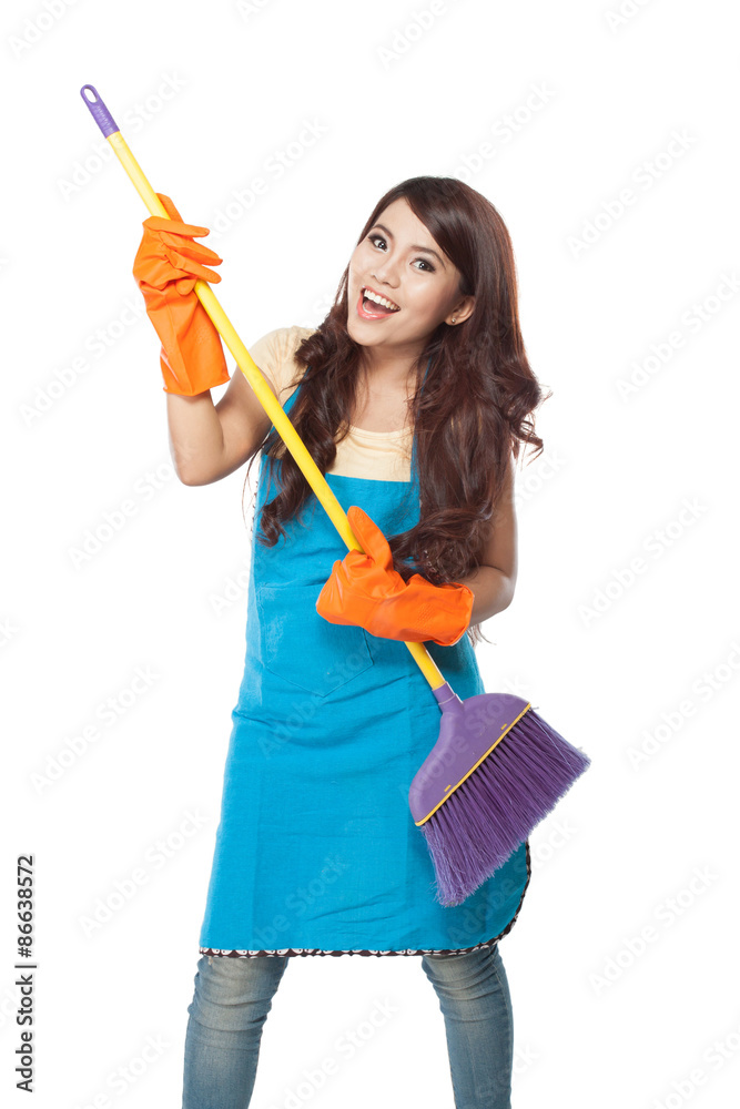 Beautiful young asian woman holding a broom, use it like a guita Beautiful young asian woman holding a broom, use it like a guita