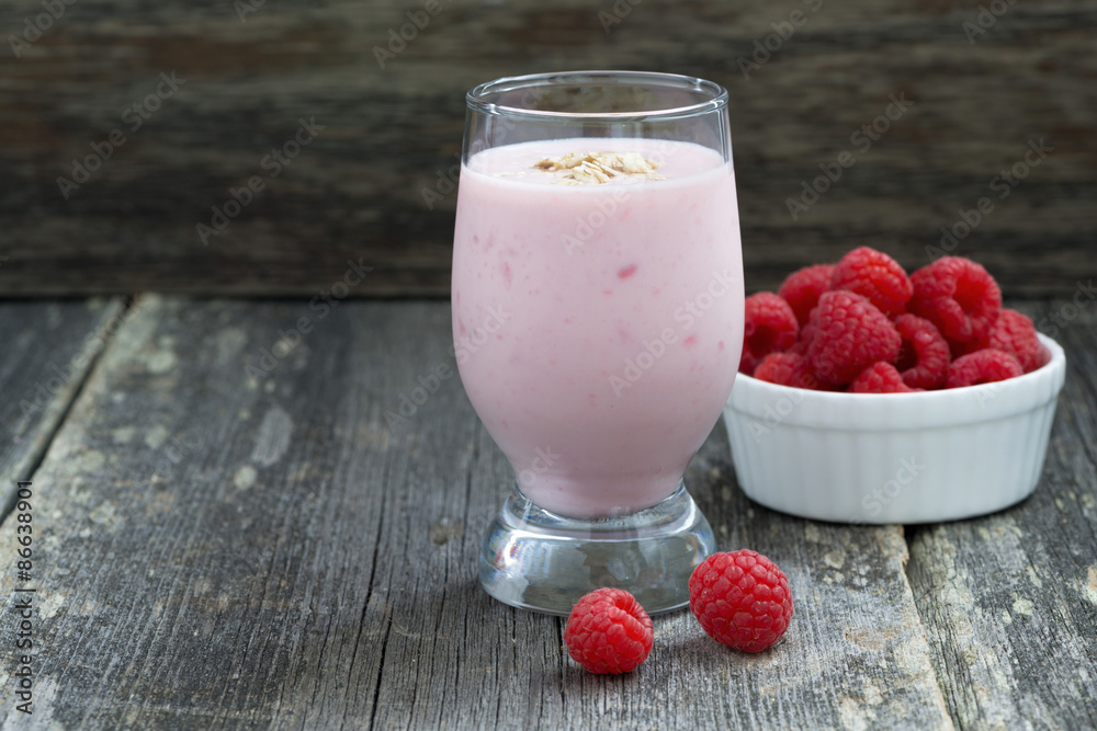 berry milkshake and fresh raspberries on a wooden background berry milkshake and fresh raspberries on a wooden background