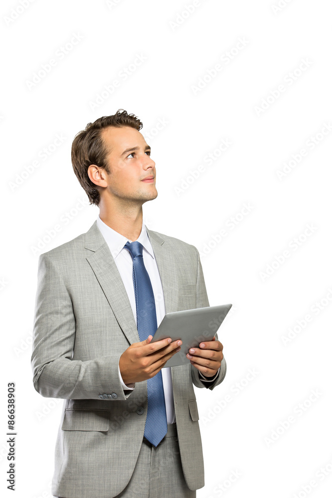 attractive businessman thinking while holding a tablet
