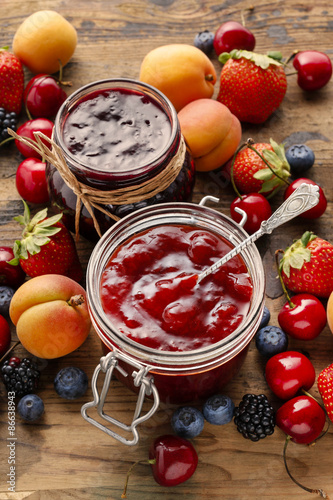 Strawberry and blueberry jams in glass jars