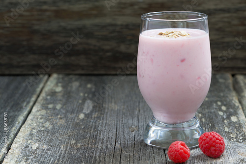 milkshake with raspberries on a wooden background, close-up