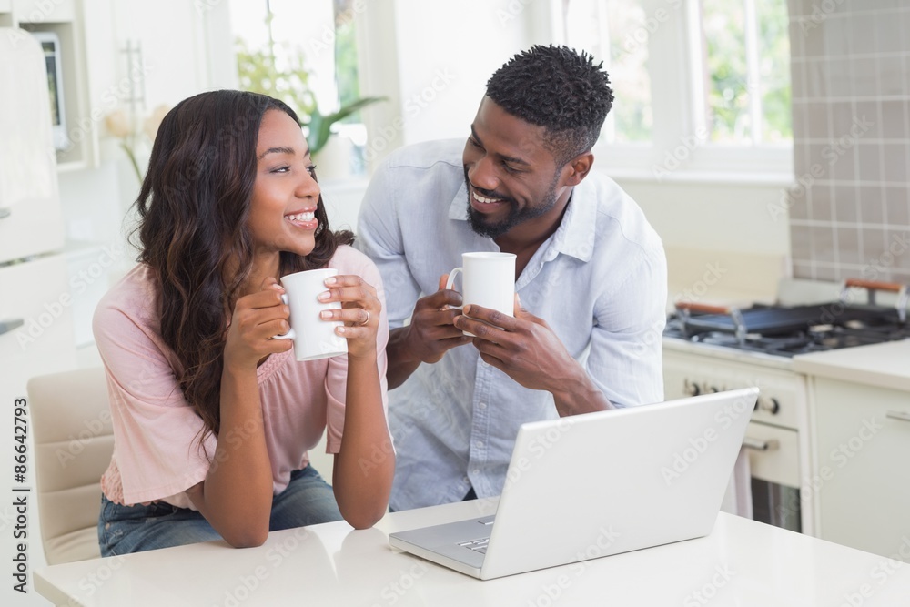 Happy couple using laptop together