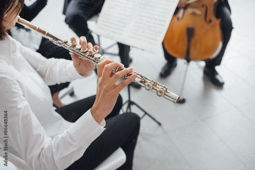 Fototapeta premium Flutist playing her instrument on stage