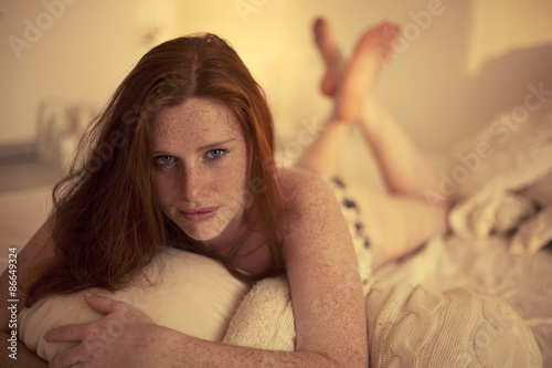 Freckled redhead in a bedroom at Sunset photo