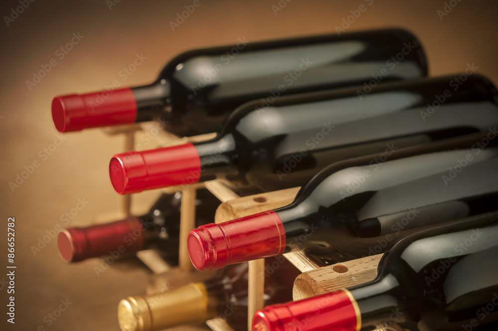 wine bottles stacked on wooden racks shot with limited depth of field wine bottles stacked on wooden racks shot with limited depth of field