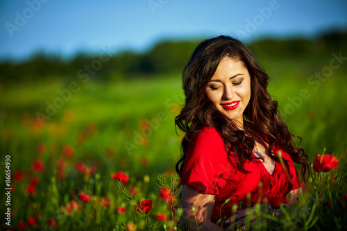 Beautiful woman in a poppy field with flowers