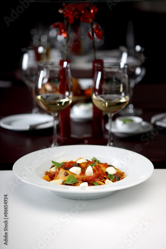 Tagliatelle in a tomato sauce with mozzarella and mint, Italian pasta, shallow depth of field, studio shot