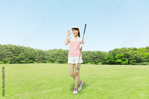 ゴルフ場に立つ女性 OKサイン