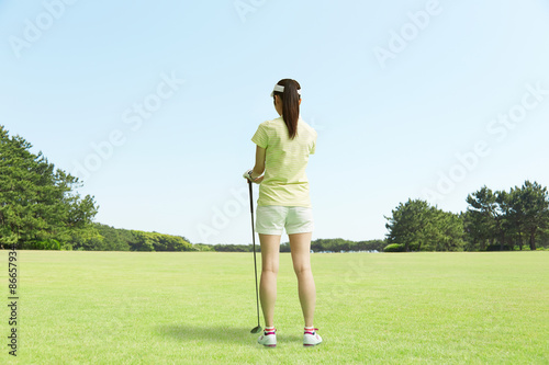 ゴルフ場に立つ女性 後ろ姿