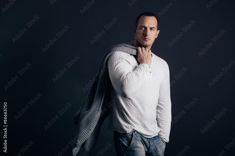 Man's style. Male model posing in studio on dark background. Casual outfit