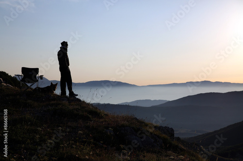 uomo guarda l  alba sulle montagne e nebbia