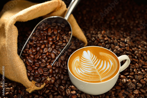 Cup of coffee latte and coffee beans on wooden table
