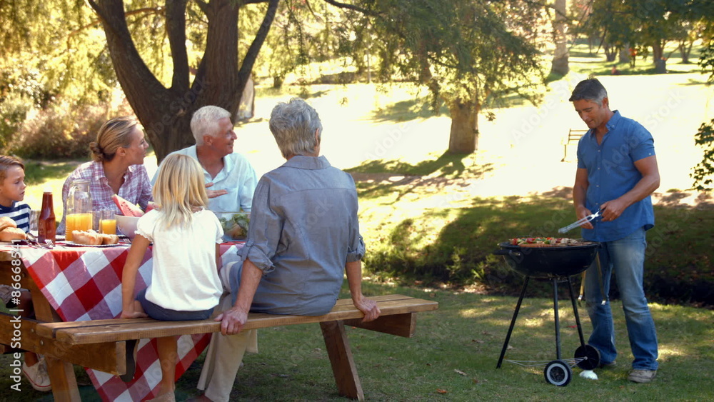 Happy man doing barbecue for his family Happy man doing barbecue for his family