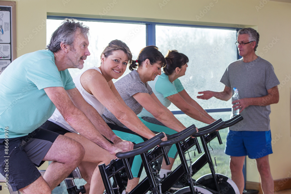 Group of seniors using spinning bikes Group of seniors using spinning bikes