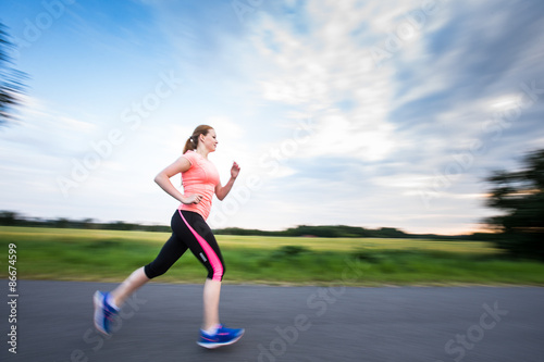 Young woman running outdoors on a lovely sunny winter/fall day  © lightpoet