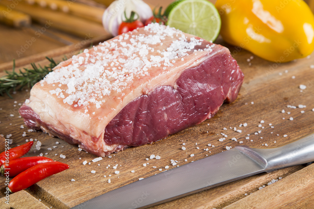 Raw meat selection on wooden cutting board with knife Raw meat selection on wooden cutting board with knife