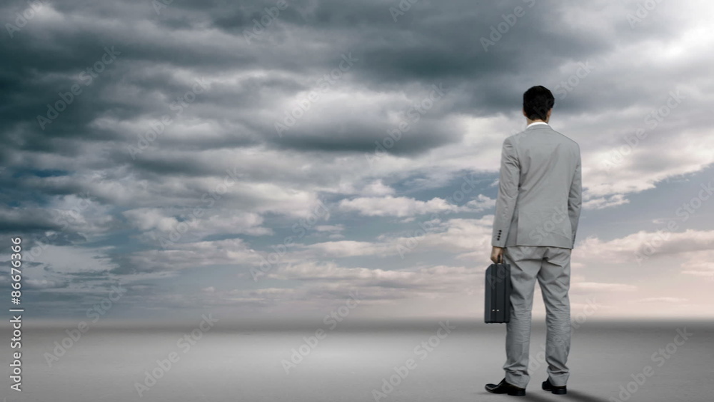 Businessman looking at brainstorm in desert Businessman looking at brainstorm in desert