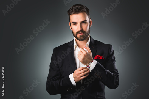 Man's style. Elegant young man getting ready. Dressing suit, shirt and cuffs
