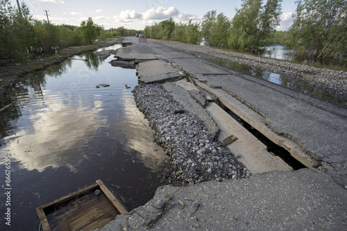The consequences of the flood washed  road with sagging plates