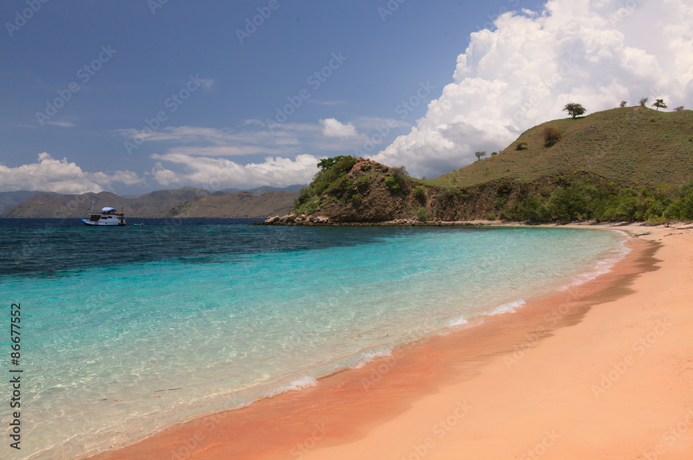 Pink beach and turquoise sea with a mountain island in 

Indonesia