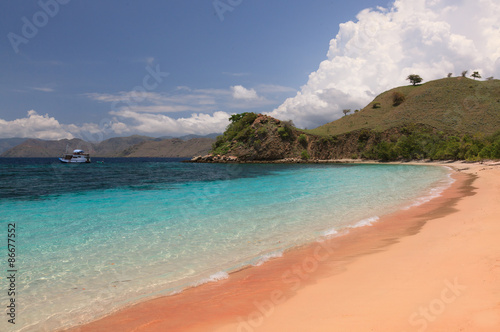 Pink beach and turquoise sea with a mountain island in     Indonesia