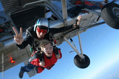 Photo Instructor skydiving jump from the plane and his student shouts.