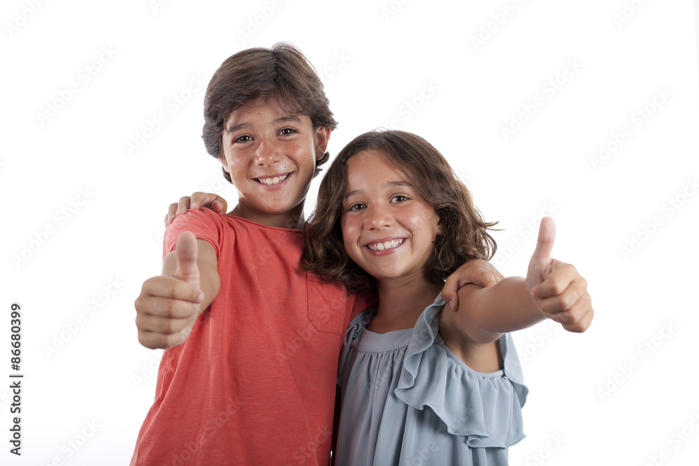 Niño y niña sonriendo y levantando el pulgar