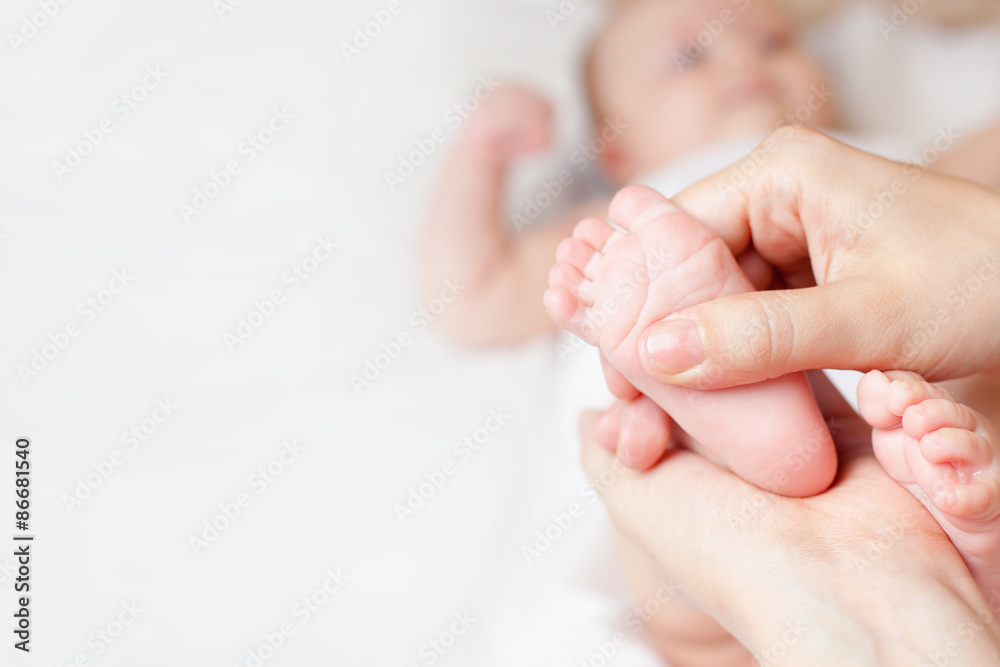Mother makes massage for happy baby, apply oil on the foot, with white background and large copy space for any text Mother makes massage for happy baby, apply oil on the foot, with white background and large copy space for any text