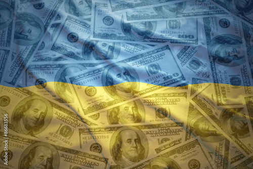 colorful waving ukrainian flag on a american dollar money background