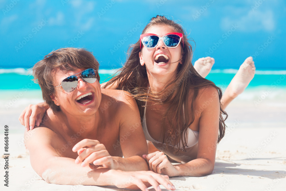 Fototapeta premium Closeup of happy young caucasian couple in sunglasses smiling at