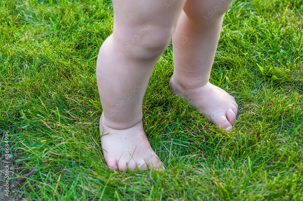 Kleinkind barfuß auf Rasen