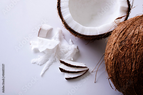 Whole and halved coconuts shot from above on a white backgroundfrom above photo