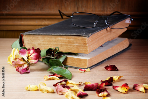 Dry rose and the old book on a table