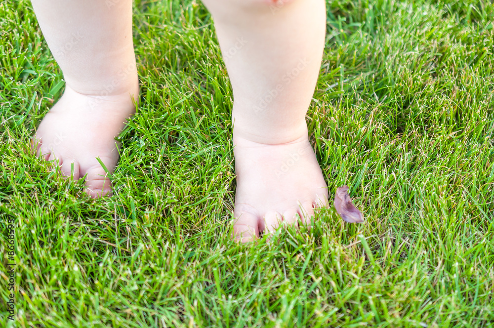 Kleinkind barfuß auf Rasen