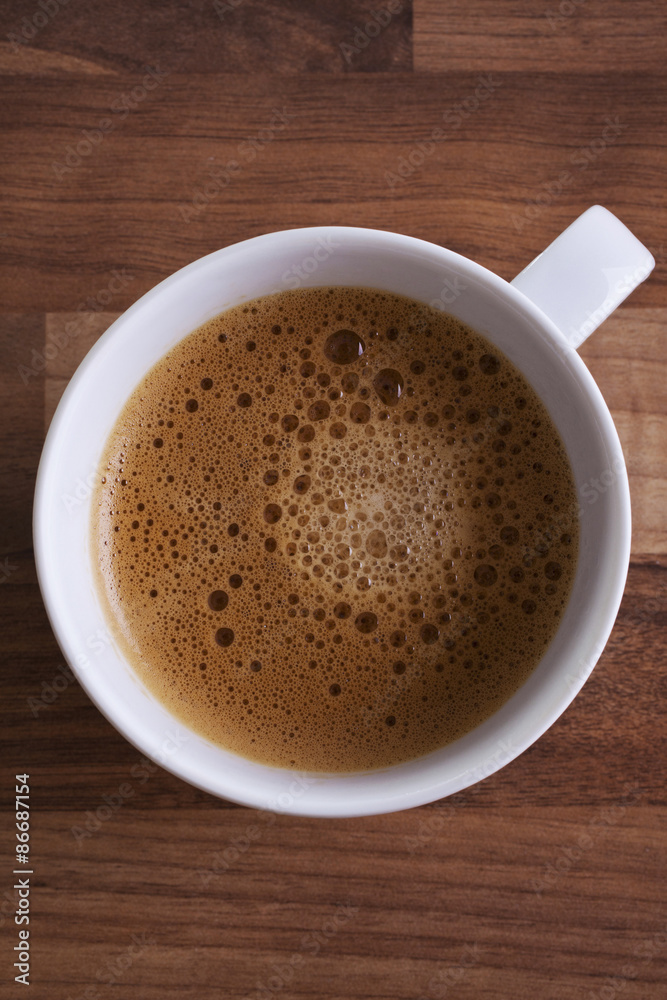 Cup of coffee shot from above on a wooden background Cup of coffee shot from above on a wooden background