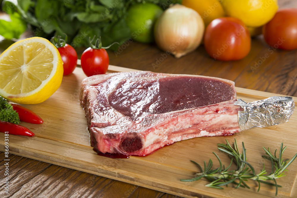 Raw meat selection on wooden cutting board with knife Raw meat selection on wooden cutting board with knife