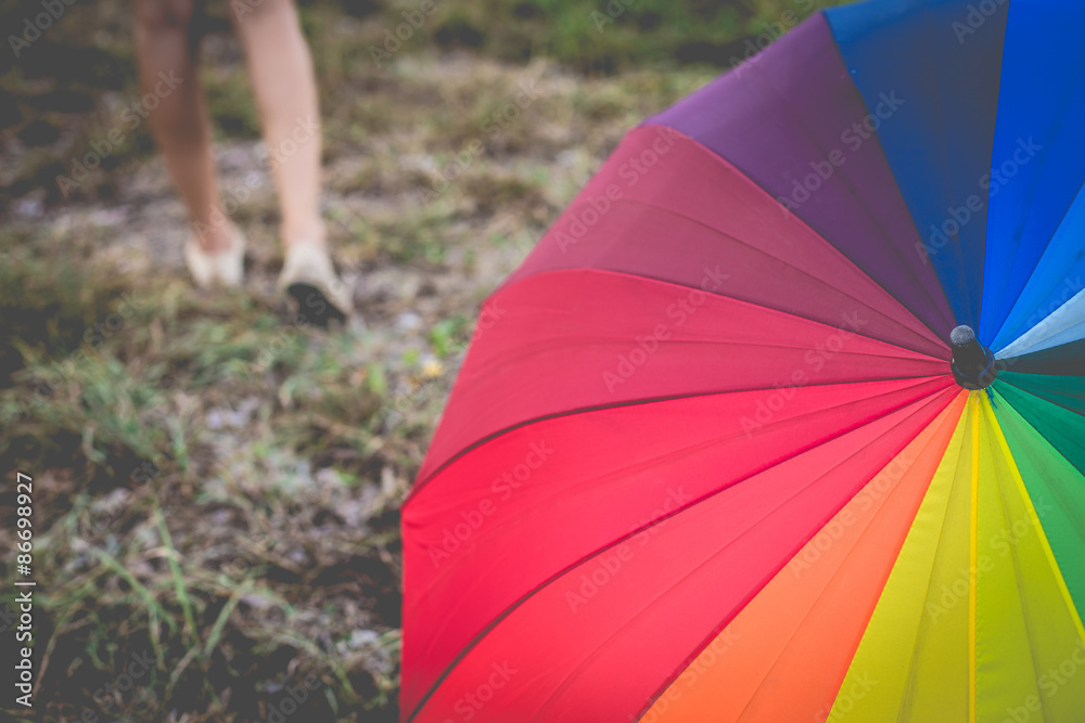 Farewell rainbow umbrella in grass field vintage and retro tone,