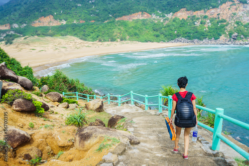 The girl is walking on a road to the beach 