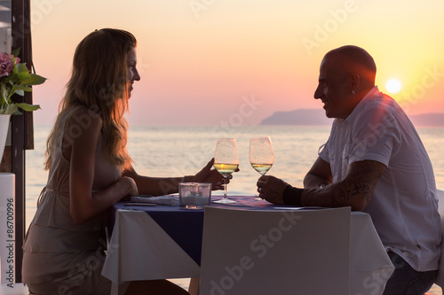 Dating couple drinking wine in sea restaurant at sunset © Evgeniya